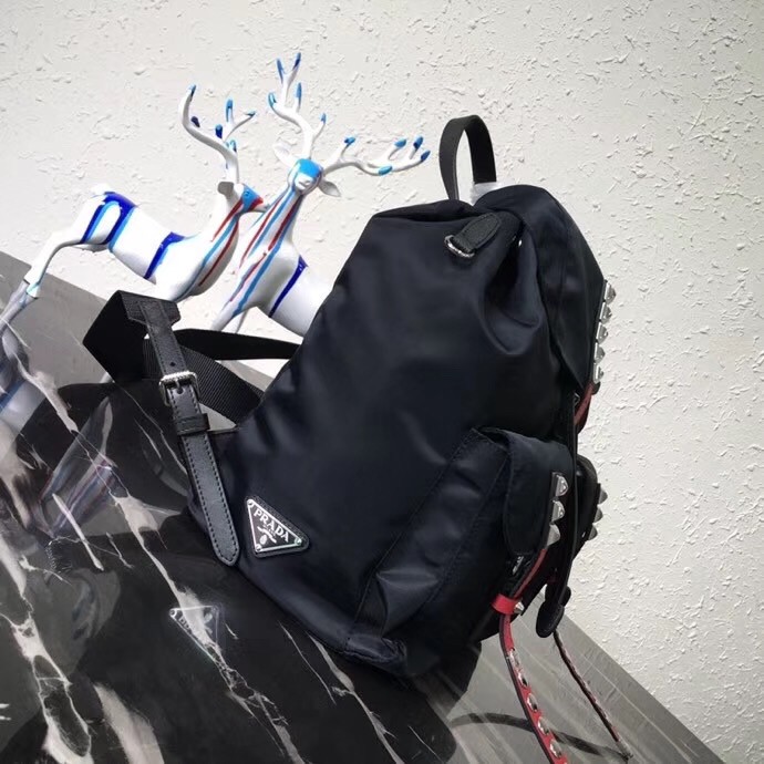 Pra*a black nylon backpack with red metal studs
