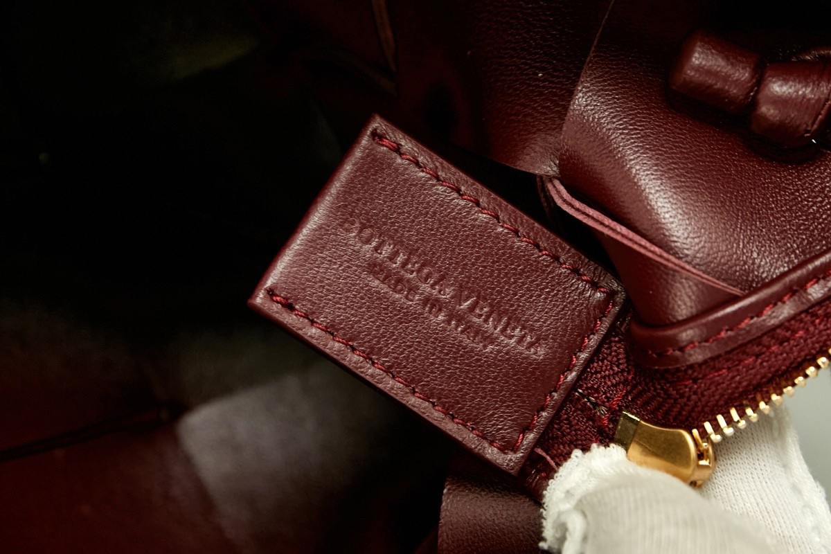 bo*te*ga Ve*ne*ta mini cassette camera bag in bordeaux lambskin