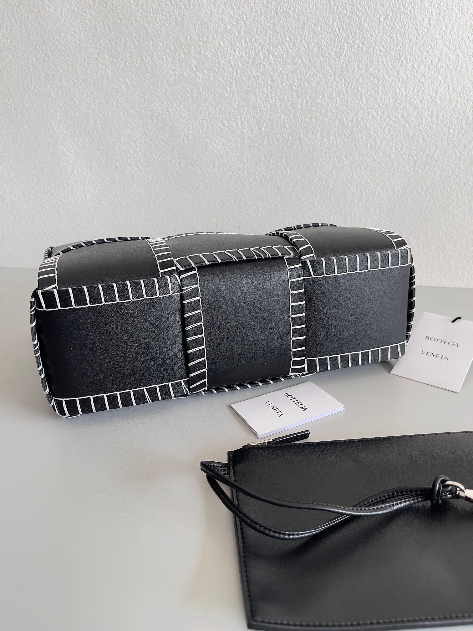 bo*te*ga Ve*ne*ta black arco small tote with white overlock stitching