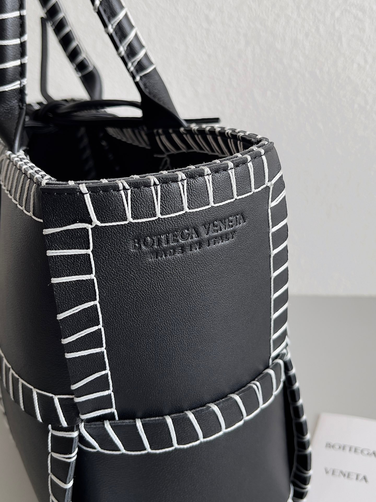 bo*te*ga Ve*ne*ta black arco small tote with white overlock stitching