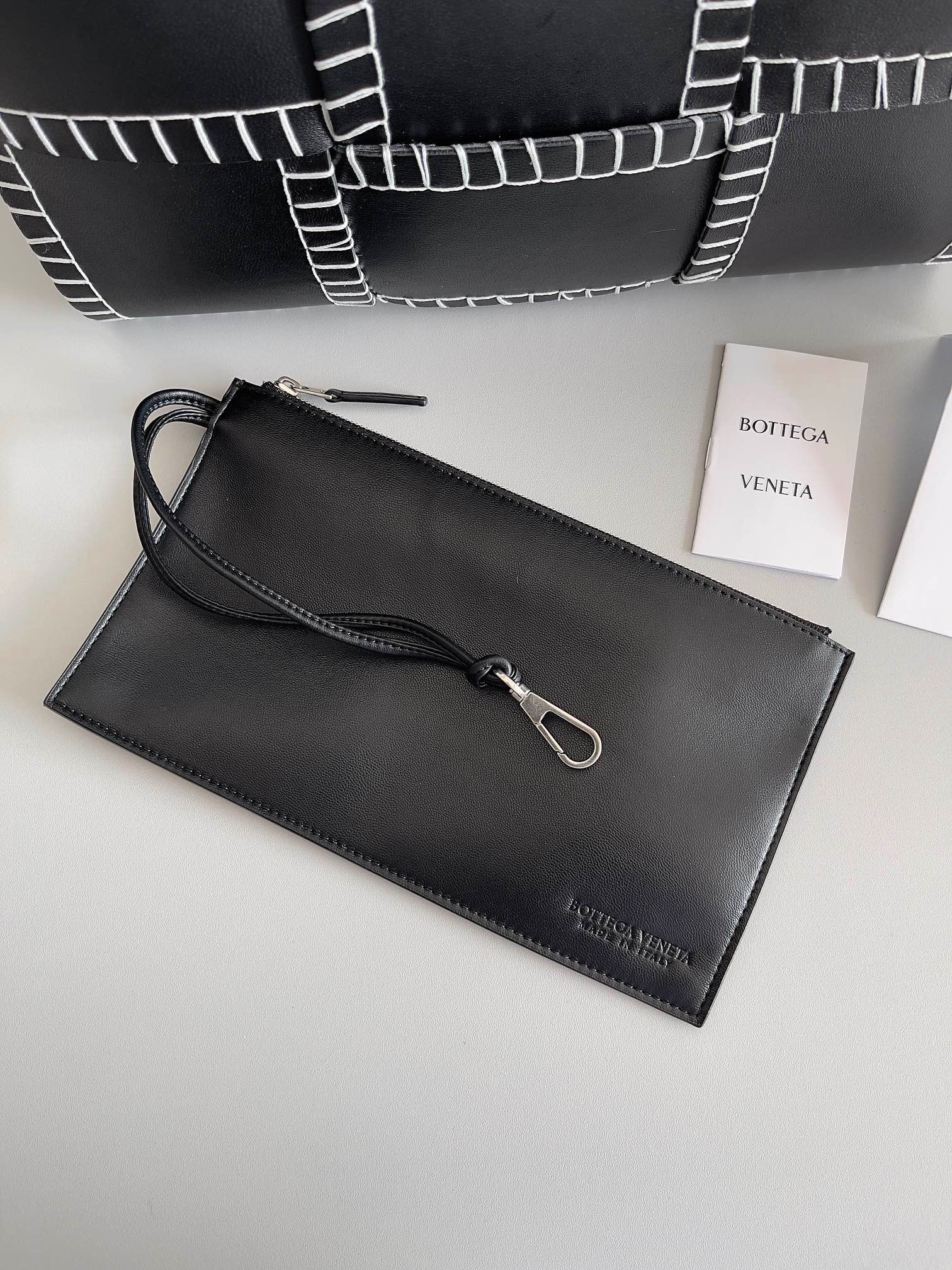 bo*te*ga Ve*ne*ta black arco small tote with white overlock stitching