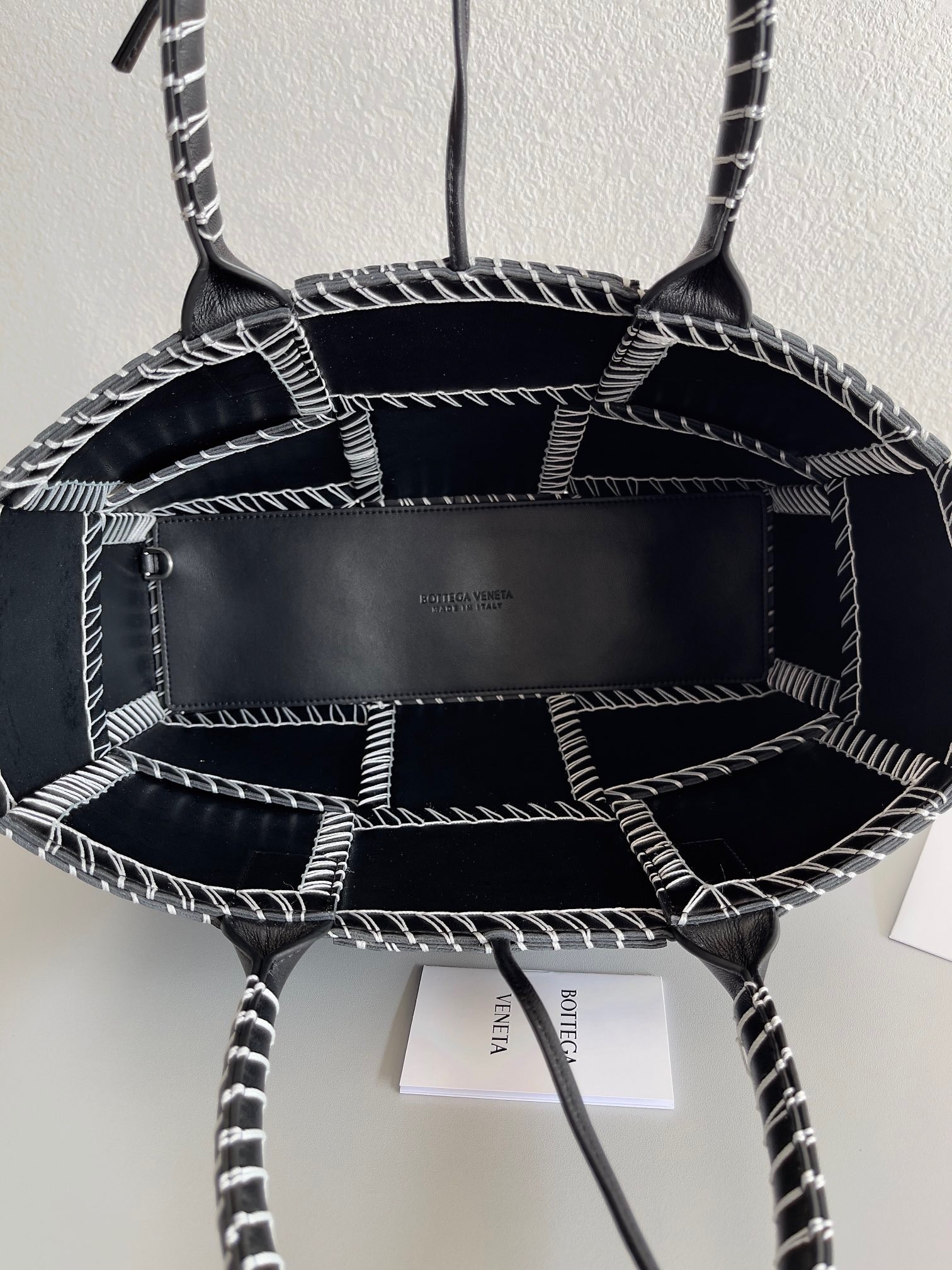 bo*te*ga Ve*ne*ta black arco small tote with white overlock stitching