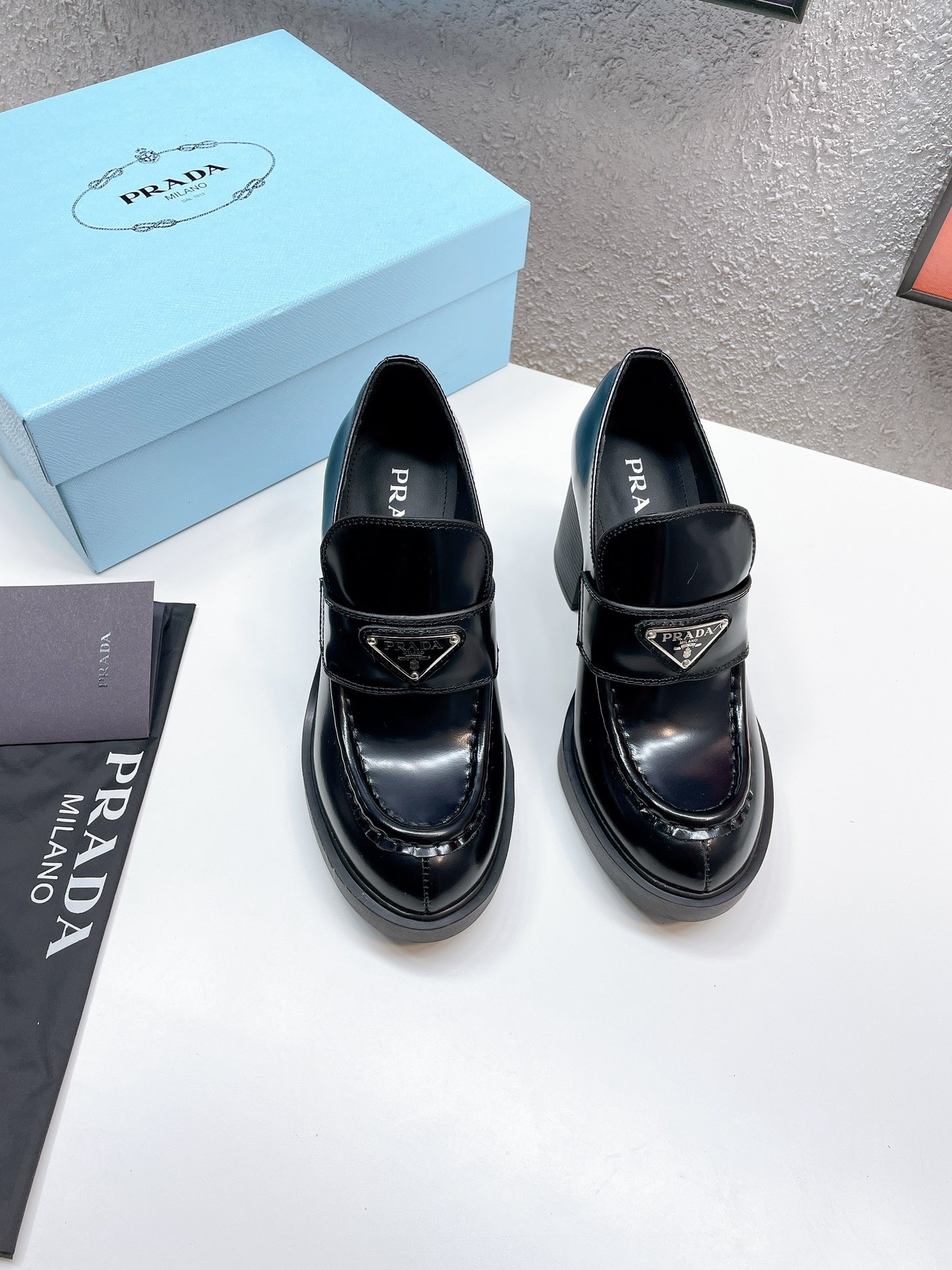 Pra*a chocolate high-heeled loafers in black brushed leather